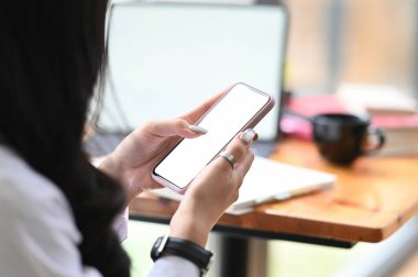 Cropped shot of young female looking for an idea from smartphone for her project.