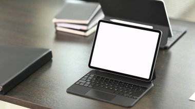 Tablet computer with blank screen and case on dark modern workspace.