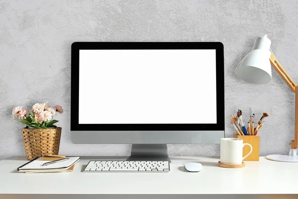 Front view of workspace with blank computer screen for graphic display montage.