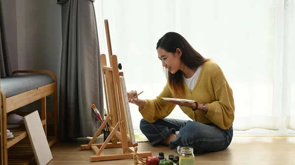 Uma Jovem Artista Feminina Pintando Sobre Tela Enquanto Sentada Chão — Fotografia de Stock