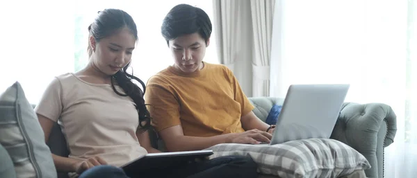 若いカップルは インターネットをサーフィンノートパソコンとソファの上でリラックス — ストック写真
