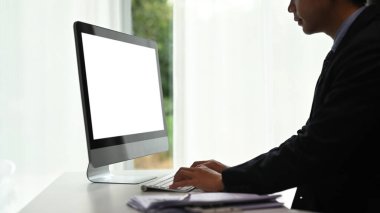 Serbest çalışan grafik tasarımcı modern çalışma alanında bilgisayar üzerinde çalışıyor..