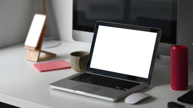Boş ekran dizüstü bilgisayarı, bilgisayarı ve akıllı telefonu olan fotoğrafçı çalışma alanı.