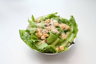 Bir kase sezar salatası ve sağlıklı yeşil salata, domuz pastırması ve kızarmış ekmek..