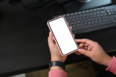 İş yerinde elinde boş ekranla cep telefonu tutan bir kadının yakın görüntüsü. Grafik görüntüleme kurgusu için boş ekran.