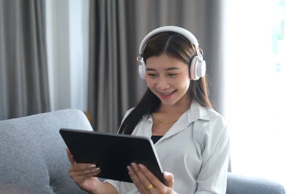 Una Mujer Alegre Con Auriculares Sentados Sofá Usando Tableta Disfrutando — Foto de Stock