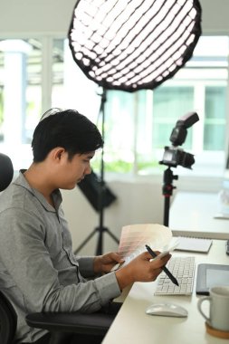 Grafik tasarımcısı veya fotoğrafçının yan görünümü seçim için renk örnekleriyle çalışıyor.