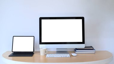 Tahta ofis masasında boş ekranı olan bilgisayar ve dijital tabletin ön görüntüsü.