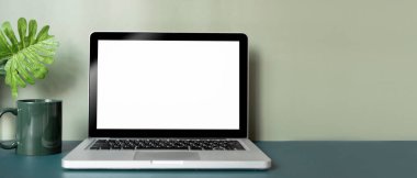 Boş ekran, kahve fincanı, bitki ve fotokopi alanlarını koyu mavi masadaki bilgisayar laptopunu kapat.