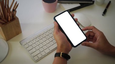 İş yerinde akıllı telefon tutan işadamının yakın görüntüsü. Reklam metni için boş ekran.