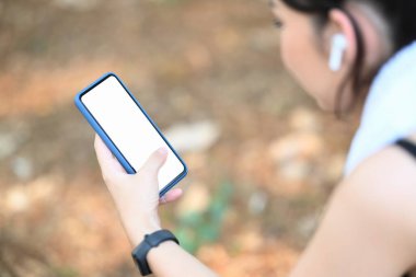 Sporcu kadının kapalı görüntüsü egzersizden sonra ara verir ve cep telefonu kullanır..