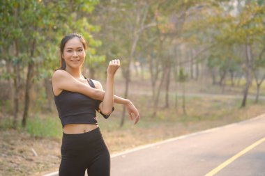 Kameraya gülümseyen ve koşmadan önce kollarını açan sağlıklı bir kadın..