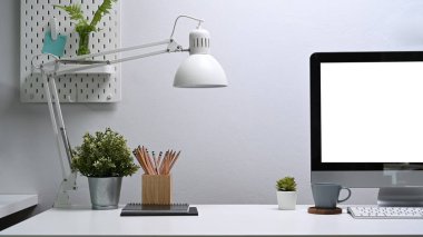 Beyaz ofis masasında bilgisayar ve ofis malzemeleri olan rahat bir iş yeri..
