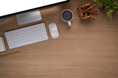 Ahşap arka planda bilgisayar, kalem tutacağı, defter ve kahve fincanı olan ofis masasının genel görünümü.