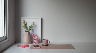 Kahve fincanı, akıllı telefon, saksı ve beyaz masadaki fotokopi alanı olan kadın işyeri.