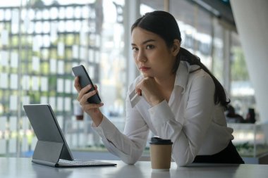 Elinde akıllı telefon ve kredi kartı olan genç bir kadın internet üzerinden satın alma konusunda endişeli ya da sorun yaşıyor.