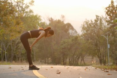 Genç sporcu kadın dışarıda koştuktan sonra mola veriyor..