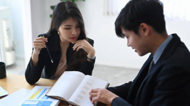 İki başarılı iş adamı toplantı odasında şirketin mali stratejisini tartışıyor..