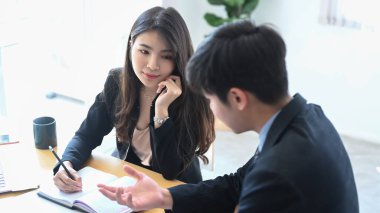 İki yönetici iş adamı birlikte çalışıyor ve yeni projelerini ofiste tartışıyorlar..