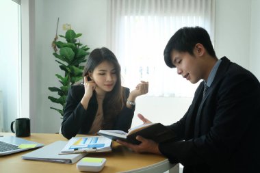 Modern ofiste yeni projeyi tartışan iki iş arkadaşı.