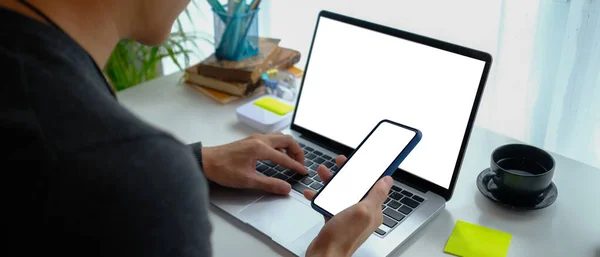 Över Axeln Närbild Man Holing Mobiltelefon Och Arbetar Med Bärbar — Stockfoto