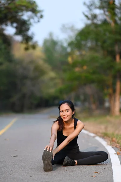 Genç Kadın Yaz Akşamı Parkta Koşmadan Önce Isınıyor Bacaklarını Esnetiyordu — Stok fotoğraf