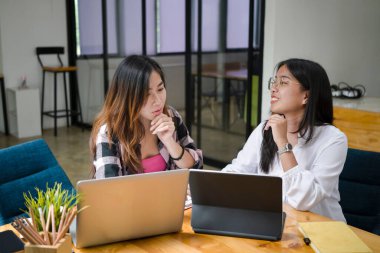 İki genç yaratıcı kadın projelerini tartışıyor ve ortak çalışma alanında birlikte çalışıyorlar..