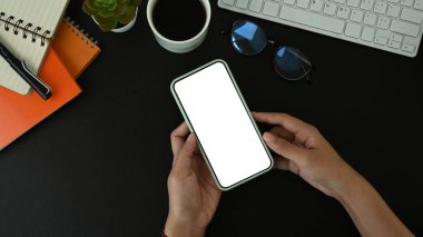 Elinde cep telefonu olan siyah derili bir kadının üst görüntüsü..