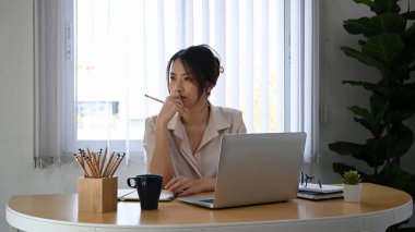 Düşünceli iş kadını pencereden bakar ve sorunu çözmeyi düşünür..