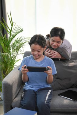 Two young asian girl playing video games together at home.