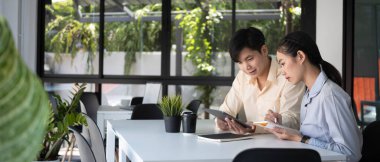 İki genç iş adamı modern ofiste yeni iş projesini tartışıyor..