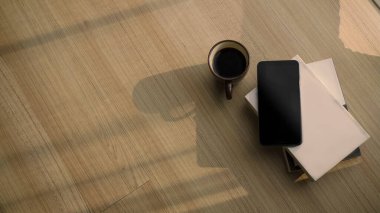 Kitaplar, kahve fincanları ve ahşap zeminde akıllı telefonlar olan rahat bir yer..