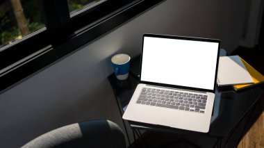 Ofisteki siyah masaya boş ekran, evrak ve kahve fincanı ile bilgisayar laptopunu yapıştır.