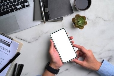 İş adamı görüşünün üstünde ve mermer arka planda beyaz ekranlı akıllı telefonu tutuyor..