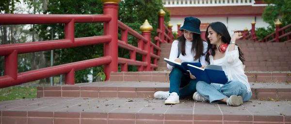 Zwei Asiatische Studentinnen Mit Lesebuch Und Gespräch Über Den Gemeinsamen — Stockfoto