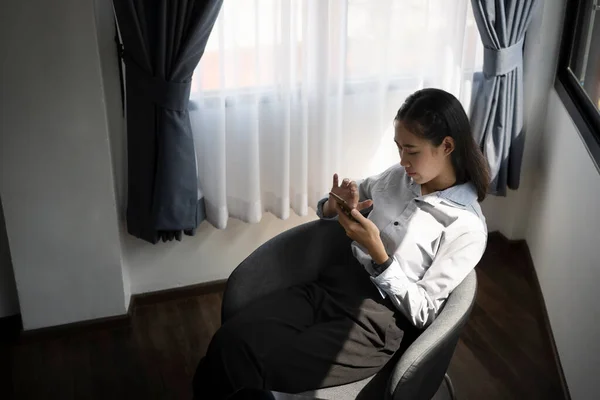 Casual Jovem Mulher Asiática Sentada Cadeira Confortável Usando Telefone Inteligente — Fotografia de Stock