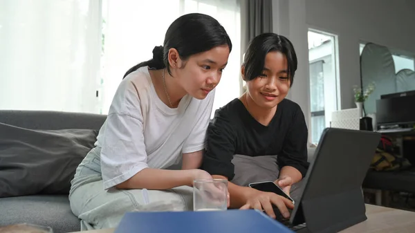 Two Young Asian Girl Using Computer Tablet While Sitting Together — Φωτογραφία Αρχείου