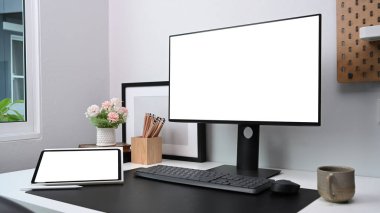 Beyaz masa üzerinde bilgisayar, dijital tablet ve ofis malzemeleriyle çağdaş çalışma alanı.