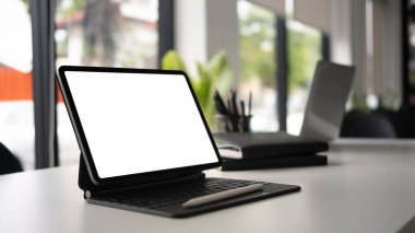 Beyaz ofis masasında kablosuz klavye ve stil kalemle dijital tablo görünümünü kapat.