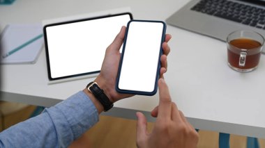 İş adamının imodern işyerinde otururken elinde boş ekranla akıllı bir telefon tutmasını kapat.