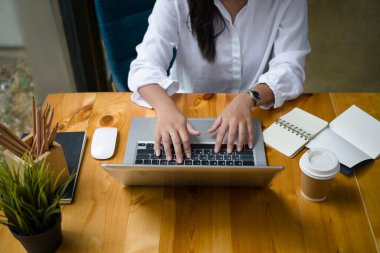 Modern kafede dizüstü bilgisayarla internette sörf yapan genç bir kadının görüntüsü..