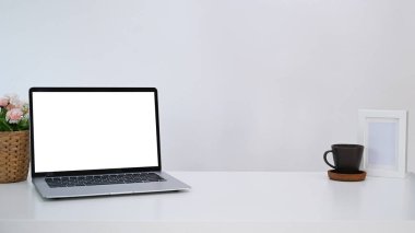 Bilgisayarı, kahve fincanı ve çerçevesi olan beyaz ofis masası. Ürün görüntüleme kurgusu için boş ekran.
