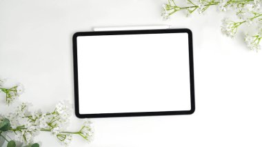 Güzel çiçeklerin üst manzarası, tablet ve beyaz çiçek mermer arka planda