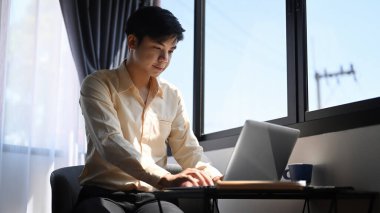 Ofiste bilgisayar bilgisayarı üzerinde çalışan yakışıklı bir iş adamı..