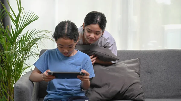 Young Asian Girl Looking Her Sister Playing Games Living Room — Stok fotoğraf