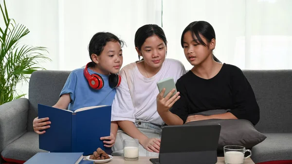 Três Meninas Sentadas Sofá Assistindo Algo Telefone Inteligente — Fotografia de Stock