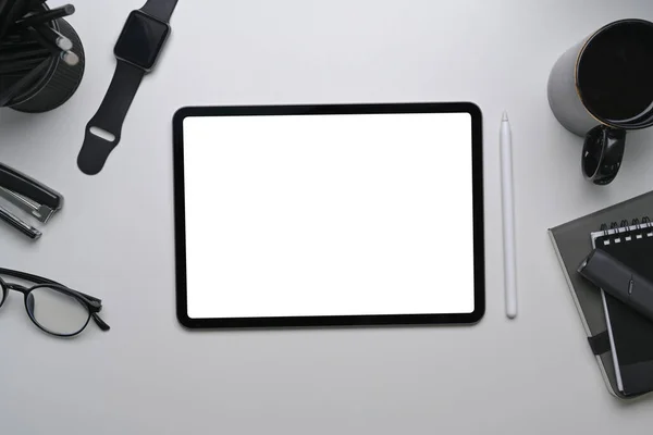 Mock up digital tablet with blank screen surrounded by various equipment on white background.