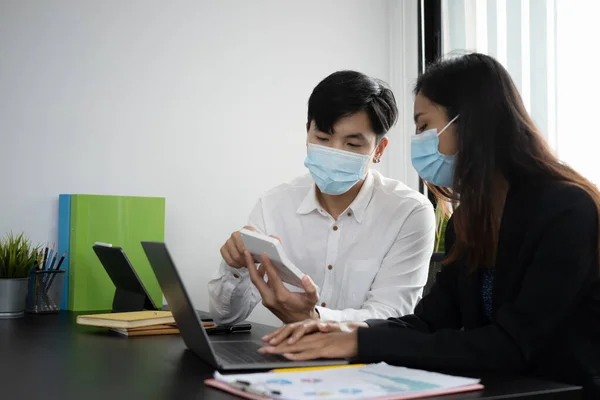 Twee Zakenmensen Dragen Een Beschermend Masker Met Rekenmachine Werken Samen — Stockfoto