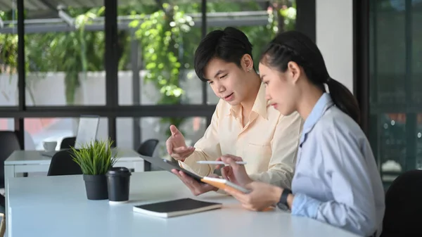 Two business consulting or talking with digital tablet on office workplace.