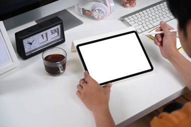 Ofis masasında dijital tablet kullanan işadamının omuz manzarasını kapat.